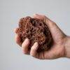 Pieza de roca de lava roja talla S-M sostenida en la mano para ver su tamaño real